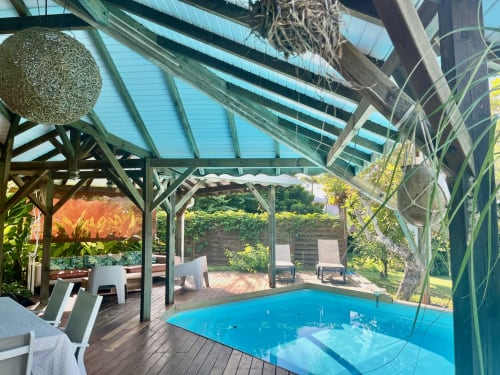Villa aux Antilles à Saint-François avec terrasse couverte, salon extérieur et vue sur jardin luxuriant