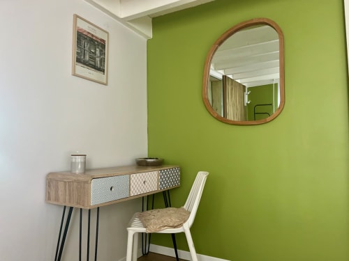 Espace bureau villa moderne avec mur accent vert, vanité bois, miroir et chaise blanche aux Villas aux Antilles à Saint-François
