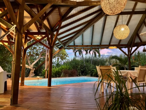 Luxueuse pergola en bois dominant la piscine de Villas aux Antilles à Saint-François, Guadeloupe, entourée de végétation tropicale