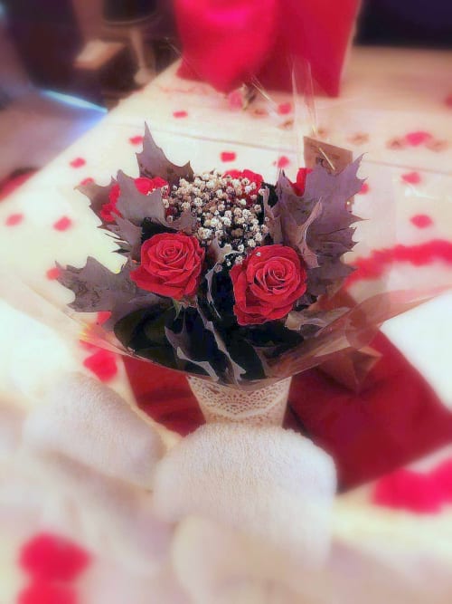 Bouquet de roses rouges et de gypsophile sur un lit romantique à la chambre d'amour Les Secrets de Winna, Deux-Sèvres