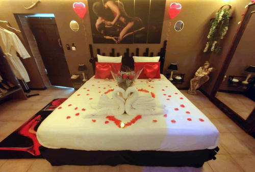 Chambre romantique avec pétales de roses et cygnes en serviettes aux Secrets de Winna près de Niort
