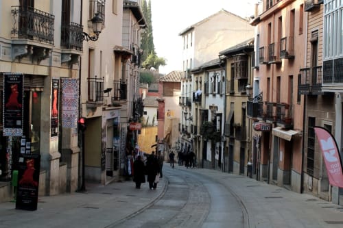 Cuesta Gomérez en Granada con edificios históricos, balcones decorativos y ambiente peatonal en el centro de la ciudad.