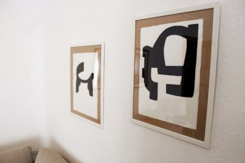 Decoración de pared con cuadros minimalistas en blanco y negro en un salón de apartamento turístico en Granada.