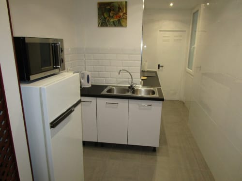 Moderna cocina equipada con electrodomésticos esenciales, diseño funcional y acabados contemporáneos.