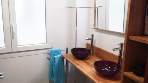 Baño moderno y elegante con lavabos dobles y detalles en madera y vidrio, ideal para una estancia confortable.