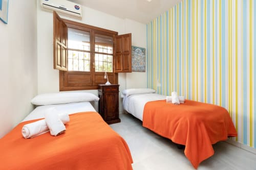 Dormitorio colorido y luminoso en el Albaicín, con camas individuales, perfecto para descansar en familia.