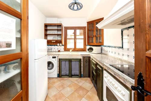Cocina equipada con estilo andaluz, espacio funcional y detalles acogedores para disfrutar de la gastronomía local.