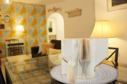 Espaciosa sala de estar con un libro artístico en la mesa, acompañada de detalles decorativos y una atmósfera acogedora.