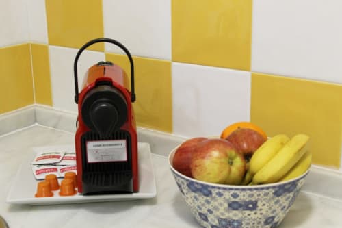 Espacio acogedor con una cafetera moderna y una fresca selección de frutas.