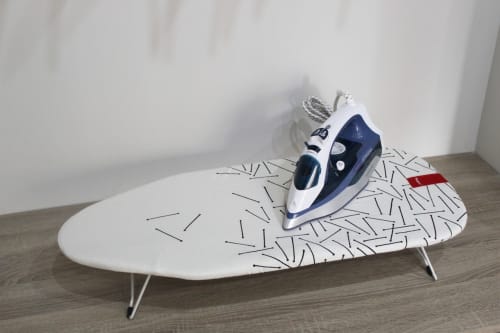 Tabla de planchar compacta con diseño moderno y plancha a vapor, ideal para espacios pequeños y funcionales.