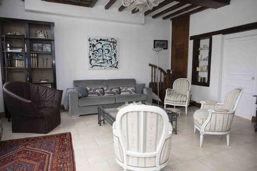Spacieux séjour du cottage Accolade à Châteaudun avec canapé gris, fauteuils rayés blanc et œuvres d'art décoratives.