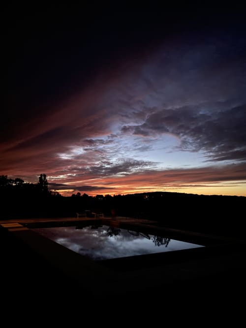 Exceptional sunset by the pool, golden reflections on the water and a serene atmosphere.