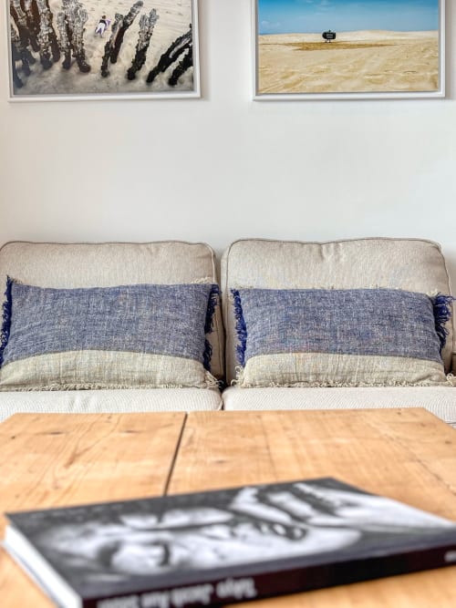 Cozy living room at Finques Garcia Enrich in Palafrugell with striped pillows, wooden table, and coastal artwork on walls