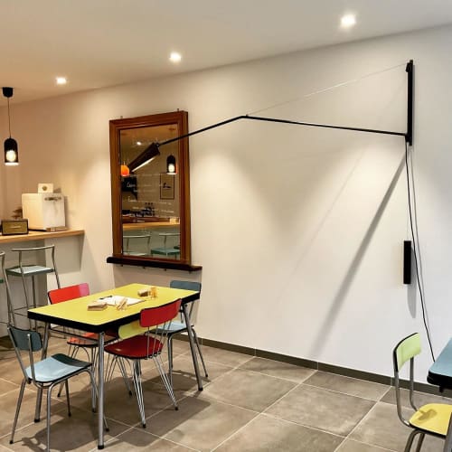 Modern breakfast room at Domaine de l'Ocrerie BnB in Pourrain with colorful chairs, yellow table, and whiteboard.