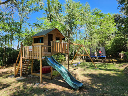 Aire de jeux en bois avec toboggan et structure d'escalade au Domaine à l'Aise, un gîte familial à Saint-Pargoire.
