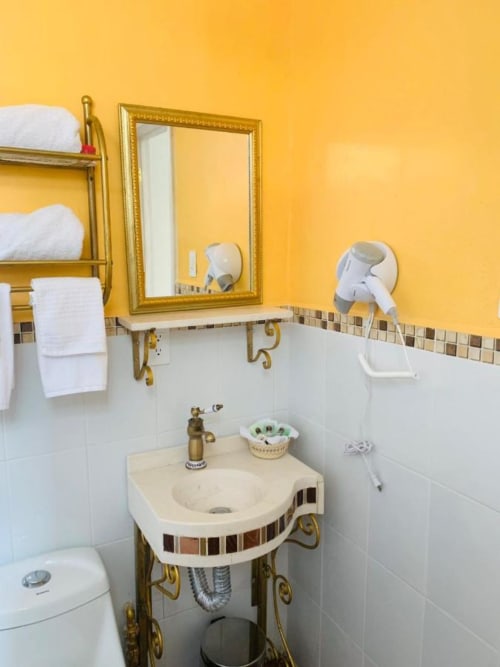 Detalle del baño con secador y toallas, de  una de las habitaciones del hotel.