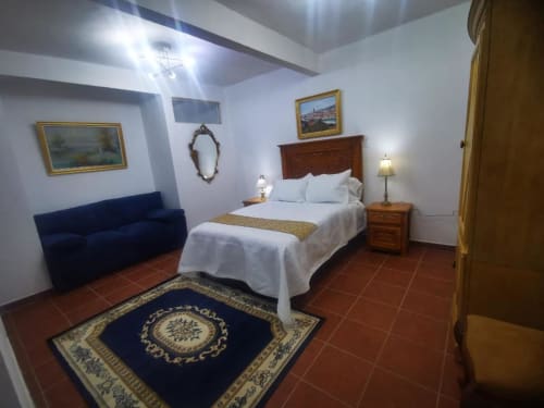 Habitación matrimonial para dos personas, con sillón para descanso.