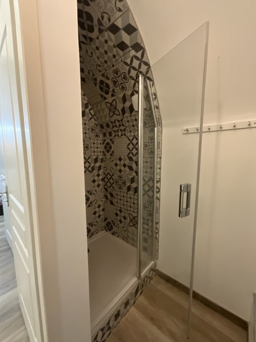 Modern shower enclosure with patterned tile wall in Gîte Auguste Poulain cottage at Locacharme, Blois