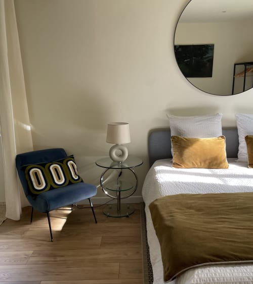 Modern hotel room at Clairseine in Tournedos-sur-Seine with bed, blue chair, round mirror, and garden view