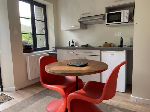 Modern kitchen-dining area with red chairs and wooden table at Clairseine cottage, Tournedos-sur-Seine