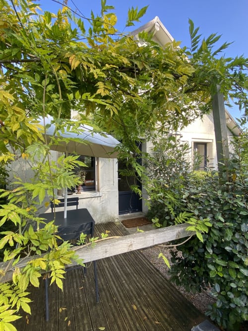 Clairseine cottage garden view in Tournedos-sur-Seine with lush green foliage, wooden deck, and private terrace access
