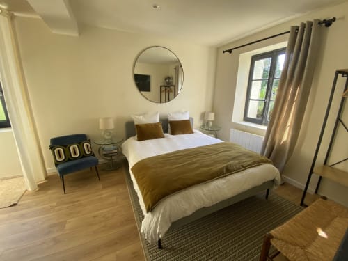 Modern bedroom with queen bed, olive green bedding, circular mirror, garden view at Clairseine B&B in Tournedos-sur-Seine,