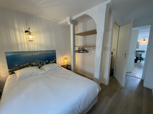 Modern bedroom at Locacharme cottage in Blois with river view headboard, white bedding, and ensuite facilities