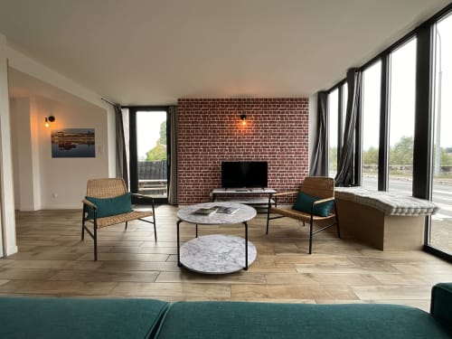 Modern living room at Locacharme cottage in Blois with brick fireplace, river views, and contemporary furnishings