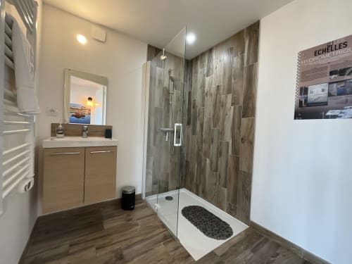 Modern bathroom at Locacharme Gîte Le Relais Viennois in Blois with walk-in shower, wooden vanity, and heated towel rack
