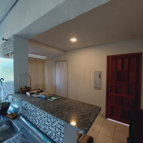 Cozinha moderna da Pousada Serra Azul em Juquiá com bancada de granito e porta de madeira vermelha
