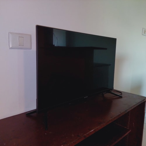 TV de tela plana escura sobre suporte no apartamento da Pousada Serra Azul, quarto com vista para a montanha em Juquiá