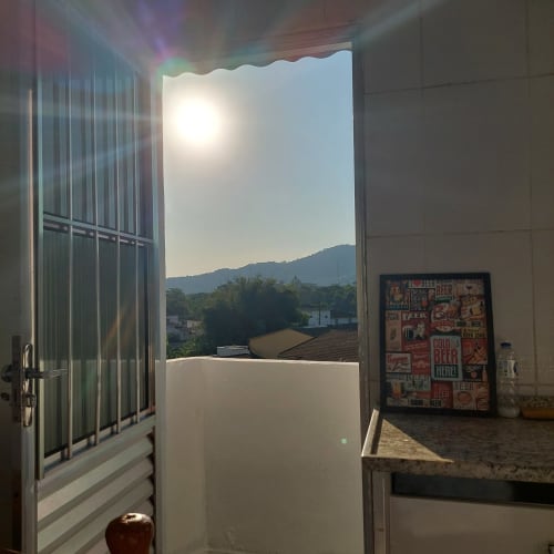 Vista luminosa do quarto na Pousada Serra Azul com porta aberta para as montanhas e vale de Juquiá