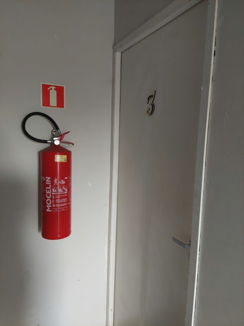 Extintor de incêndio e porta número 3 no corredor da Pousada Serra Azul, Juquiá