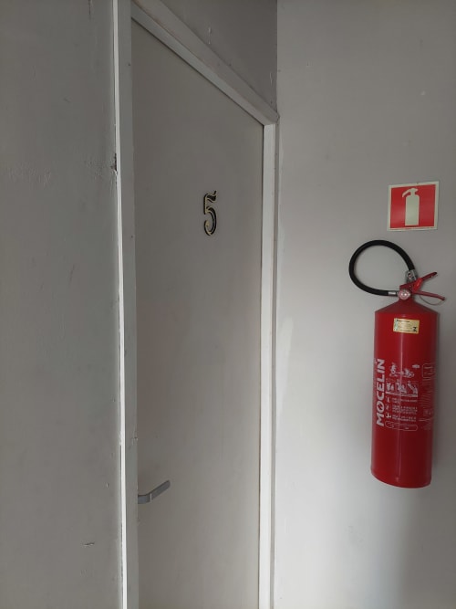 Porta 5 com extintor de incêndio no corredor da Pousada Serra Azul, Juquiá