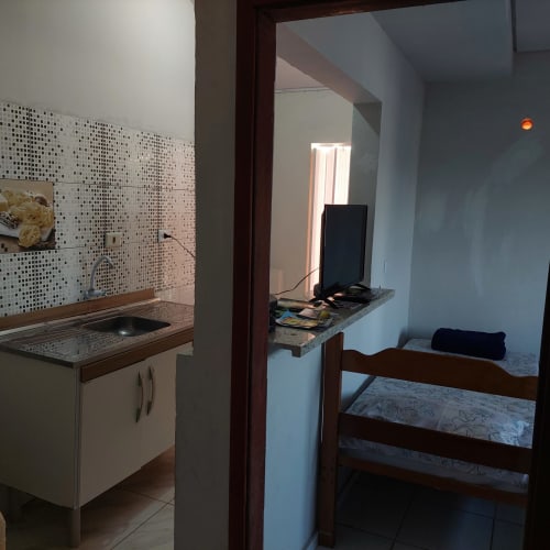 Estúdio na Pousada Serra Azul em Juquiá com kitchenette, painel de azulejos, escrivaninha e área de quarto