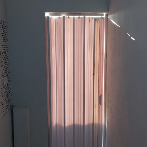 Persianas verticais iluminadas no apartamento da Pousada Serra Azul, Juquiá com vista da cidade e decoração moderna