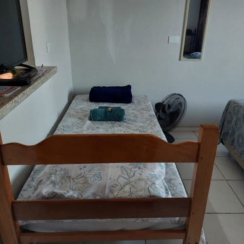 Quarto aconchegante da Pousada Serra Azul em Juquiá com cama de madeira e roupa de cama estampada