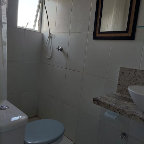 Banheiro da Pousada Serra Azul em Juquiá com chuveiro azuleijado, pia, vaso sanitário e janela