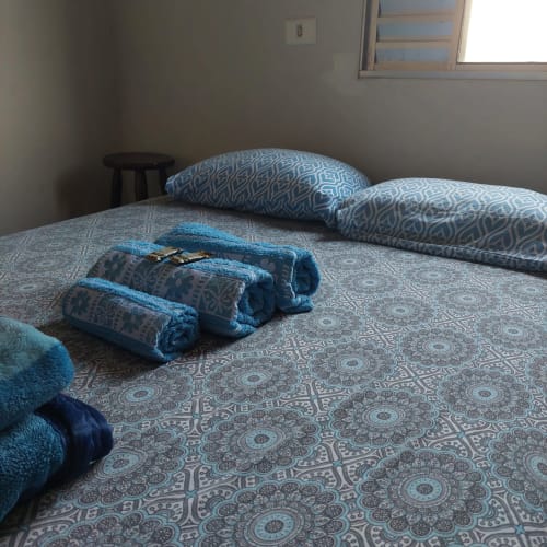 Toalhas azuis e roupa de cama estampada no apartamento da Pousada Serra Azul, Juquiá, Brasil