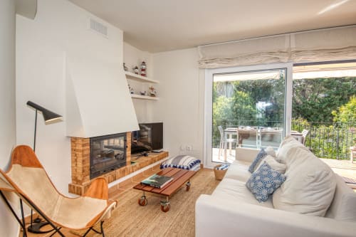 Salon moderne avec cheminée, canapé blanc et vue sur la terrasse à Finques Garcia Enrich, Palafrugell