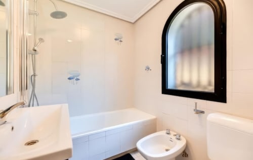 Baño moderno en apartamento SACORO, Marbella con azulejos blancos, bañera, lavabo, inodoro y espejo grande