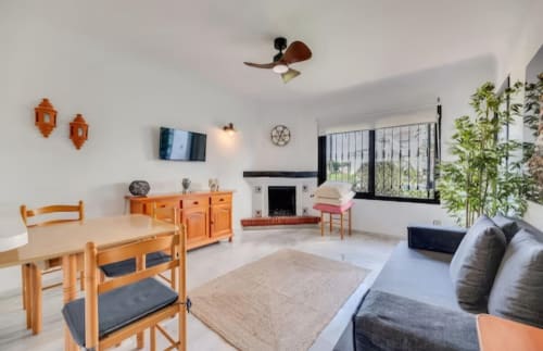 Luminoso apartamento en Marbella en SACORO con muebles de madera naranja, ventilador de techo, chimenea y comodidades modernas