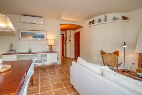 Sala de estar moderna del hotel Finques Garcia Enrich en Palafrugell con sofá blanco, azulejos de barro y decoración costera
