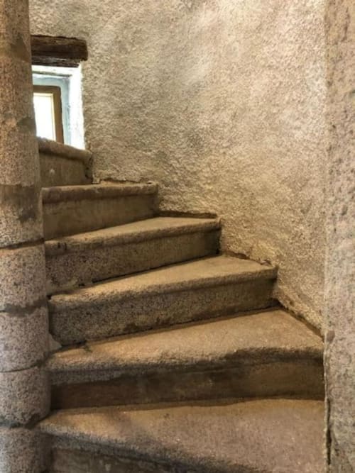 Ancient stone staircase with narrow walls at Château de Vaux Morvan, French château bed and breakfast