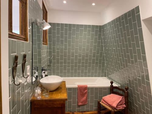 Spa bathroom at Château de Vaux Morvan with green subway tiles, vessel sink, and soaking tub in Étang sur Arroux