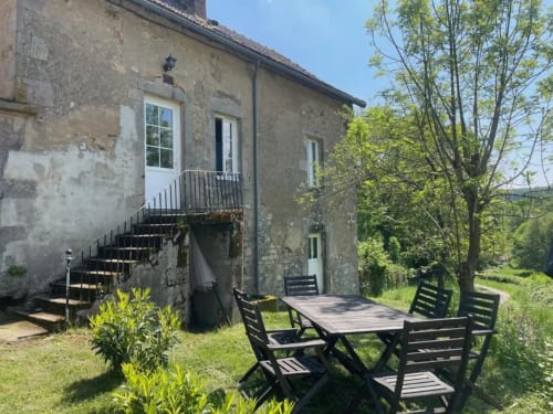 Château de Vaux Morvan patio with stone building, outdoor seating, and trees in Étang sur Arroux