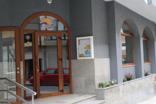 Entrada del Hotel Rego Foz con puerta de madera y ventanas arqueadas en Foz, Lugo, España