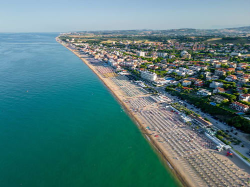 Vista aerea della spiaggia di Marcelli con ombrelloni organizzati, Mare Adriatico e zona Residence Balconi del Conero