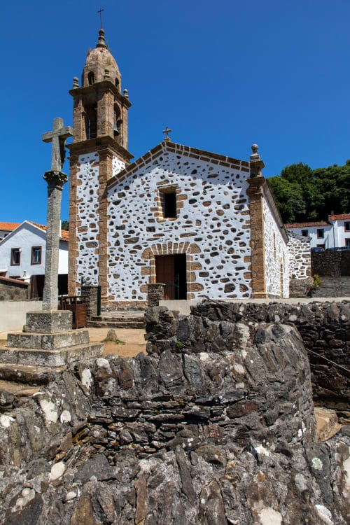 Capilla de piedra blanca con campanario y cruces en Casa Rural San Andrés de Teixido en A Coruña, Galicia