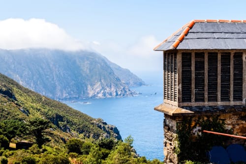 Casa Rural San Andres de Teixido, edificio de piedra con vistas a acantilados costeros y las aguas azules del Atlántico en Galicia,